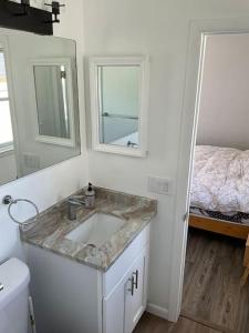 baño con lavabo, espejo y cama en Brigantine Beach Getaway, en Brigantine