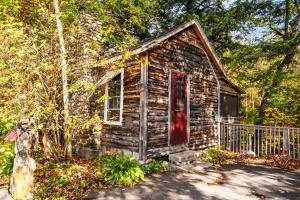 an old log cabin with a red door at Pemi Cabins in Lincoln