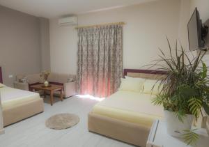 a living room with two beds and a window at Hotel Vila Dedej in Durrës