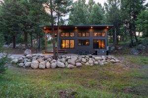 Una pequeña casa en el bosque con un montón de rocas en Private Cabin For Couples! Hike, Relax, Hot Tub!, en Philipsburg