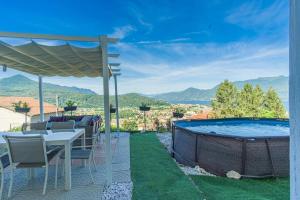 a patio with a table and chairs and a swimming pool at Vicolo dei Fiori in Luino