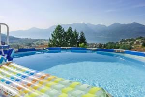 a large swimming pool with a view of the mountains at Vicolo dei Fiori in Luino