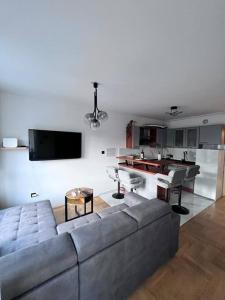 uma sala de estar com um sofá cinzento e uma mesa em Greywood relax apartment em Zagreb