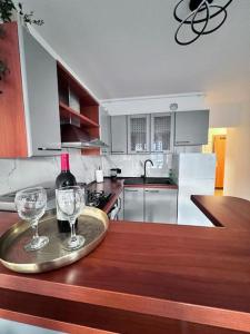 uma cozinha com 2 copos e uma garrafa de vinho numa bandeja em Greywood relax apartment em Zagreb
