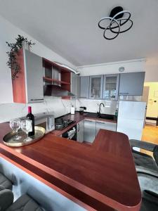 uma cozinha com uma mesa de madeira com copos de vinho em Greywood relax apartment em Zagreb
