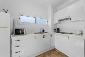 eine weiße Küche mit weißen Schränken und einem Fenster in der Unterkunft Apartamento Arcoiris in Arrieta