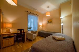 a hotel room with two beds and a desk at Romeo Family Apartments in Tallinn