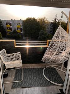 a balcony with a chair and a view of the water at Apartament Konin Makowa in Konin