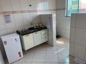 a small kitchen with a sink and a refrigerator at Apartamento Centro Alfenas 03 in Alfenas