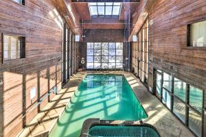 a large indoor swimming pool in a building with windows at Ski-Out Brian Head Condo - Top of Navajo Lift in Brian Head