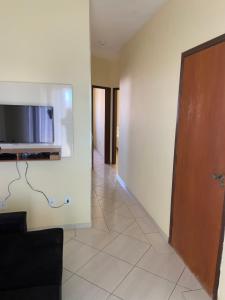a living room with a television on a wall at Apartamento Centro Alfenas in Alfenas