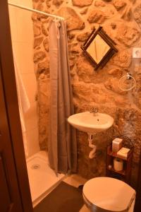 a bathroom with a stone shower and a sink at Casinha Estrela da Encosta - Gerês in Vieira do Minho