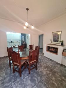 uma sala de jantar com uma mesa e cadeiras e uma lareira em MENDOZA TURiSTA - CASA EN SAN MARTÍN, MENDOZA "ANTONIO's HOUSE" em San Martín