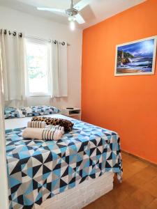 a bedroom with two beds and an orange wall at Apartamentos Atobá Flats in Juquei