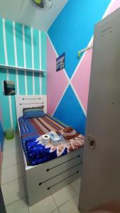 a small bed in a room with a colorful wall at 05 Burjuman metro stations Unisex Hostel Private room - 05 in Dubai