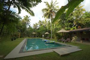 een zwembad in een tuin naast een huis bij Villa 386 in Ahungalla
