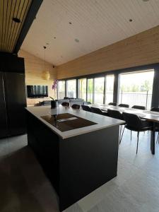 a kitchen with a island in a room with tables and chairs at Himos Villa Golden in Jämsä +11 photos