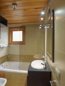 een badkamer met een wastafel en een bad bij Sol y Nieve in San Martín de los Andes