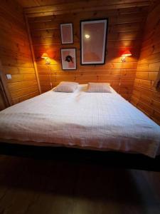 a bedroom with a large bed in a wooden wall at Himos Alahonka A in Jämsä