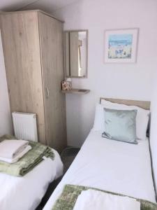 um pequeno quarto com 2 camas e um espelho em Sea breeze, modern, cosy holiday home(Wi-Fi) em Millom