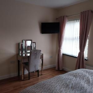 a bedroom with a desk and a chair and a window at Home from Home in Corchoney Cross Roads