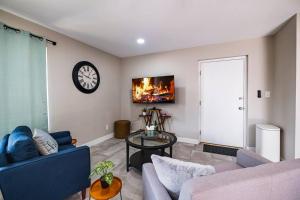 a living room with a couch and a clock on the wall at *Msg for 5%off*KingBed PoolYard GuesthouseGlendale in Glendale