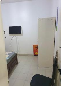 Cette chambre comprend un lit et une télévision murale. dans l'établissement Le zèbre, à Dakar