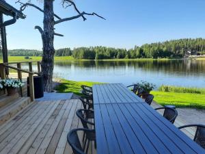 a picnic table on a deck with a view of a lake at Villa Pussilanranta Himos in Jämsä