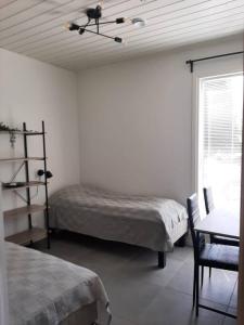 1 Schlafzimmer mit 2 Betten, einem Tisch und einem Fenster in der Unterkunft Villa Pussilanranta Himos in Jämsä