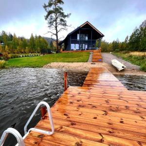 a dock with a boat on the water with a house at Villa Pussilanranta Himos in Jämsä