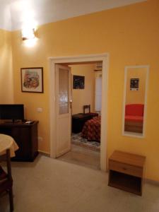 Zimmer mit einem Bett und einer Tür zum Schlafzimmer in der Unterkunft FORESTERIA DEL TEATRO in Agrigento