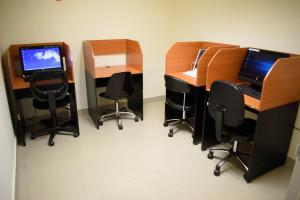 an office with three desks with chairs and a computer at Los Herederos Hotel Piedras Negras in Piedras Negras