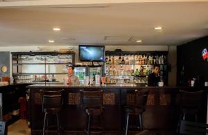 a bar with two men sitting at a bar at Los Herederos Hotel Piedras Negras in Piedras Negras