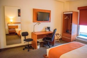 une chambre d'hôtel avec un bureau et une chambre dans l'établissement Los Herederos Hotel Piedras Negras, 