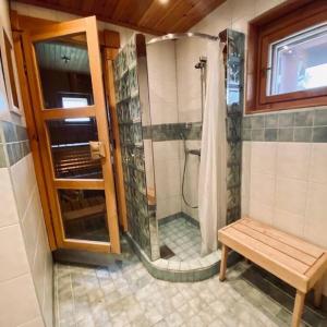 a bathroom with a shower with a bench in it at Havupirtti Himos in Jämsä