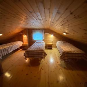 a large room with two beds in a log cabin at Havupirtti Himos in Jämsä