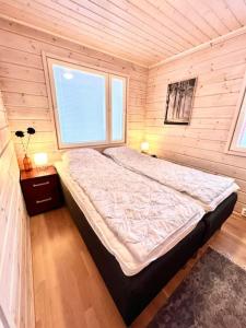 ein Schlafzimmer mit einem großen Bett in einem Holzzimmer in der Unterkunft Himoskuikka in Jämsä + 6 Fotos
