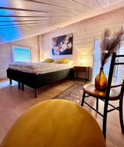 ein Schlafzimmer mit einem Bett und einem Stuhl in einem Zimmer in der Unterkunft Himoskuikka in Jämsä