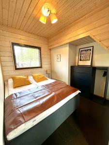 Aurinkopaikka 3 Himos في يامسا: غرفة نوم بسرير كبير في غرفة خشبية