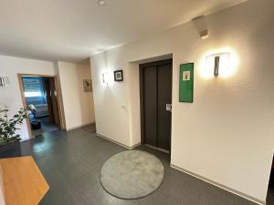 a room with a hallway with a door and a rug at Hotel Lachnerhof in Erlangen