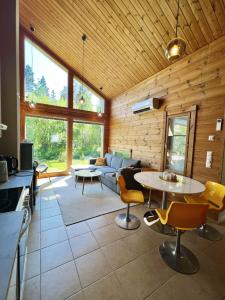 耶姆赛Himos Alahonka B的客厅里有一张沙发、一张桌子和几把椅子。