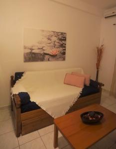a bed in a room with a table and a painting at Athena Kythera in Dhiakofti