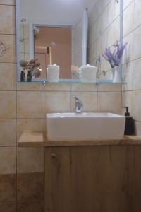 a bathroom with a white sink and a mirror at Athena Kythera in Dhiakofti