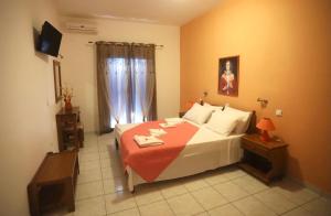 a bedroom with a large bed with a red blanket at Athena Kythera in Dhiakofti