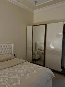 sypialnia z dużym łóżkiem i lustrem w obiekcie شقق وغرف خاصة w mieście Ha'il