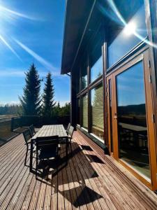 una terraza de madera con mesa y sillas en una casa en Aurinkopaikka 4 Himos, en Jämsä