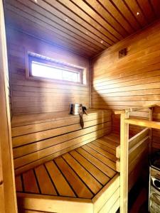 a small wooden sauna with a window in it at Aurinkopaikka 4 Himos in Jämsä