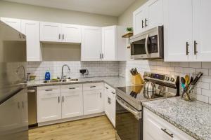 a kitchen with white cabinets and stainless steel appliances at Houston Home with Private Yard Near The Galleria in Hot Wells