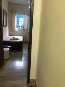 pasillo con una habitación con cama y ventana en Suíte Privativa Sanilda en Vitória
