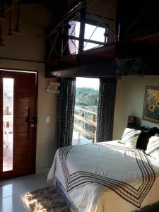 a bedroom with a bed and a large window at Chalé Adventure in Nova Cruz